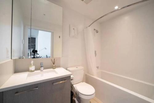 La salle de bains est pourvue de toilettes, d'un lavabo et d'une baignoire. dans l'établissement Bright and Modern Suite with Amazing views!, à Vancouver