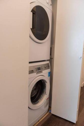 a washing machine and a dryer in a room at Bright and Modern Suite with Amazing views! in Vancouver