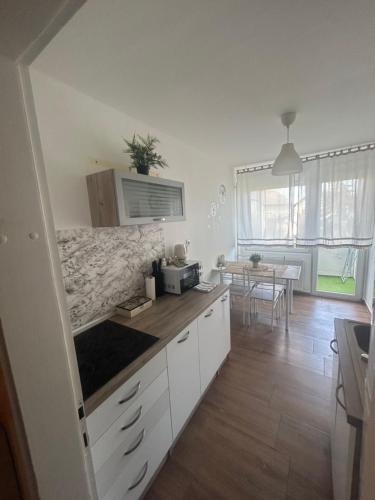 una cocina con armarios blancos y una mesa en una habitación en NO NAME, en Koprivnica