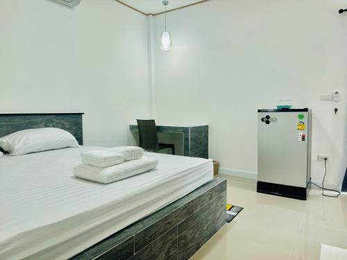 1 dormitorio con 1 cama con toallas en เป็นต่อ รีสอร์ต en Ban Kluk Faeb