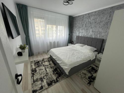 een kleine slaapkamer met een bed en een raam bij Apartament Central in Onești