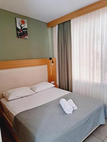 1 dormitorio con 1 cama con 2 almohadas blancas en ANDOYA pansiyon, en Bodrum City