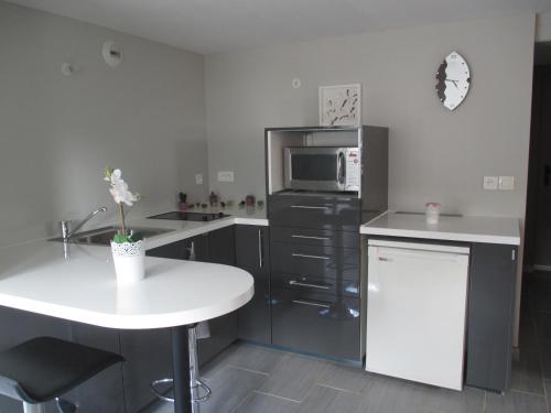 a kitchen with a white table and a microwave at Like Home in Steinbourg