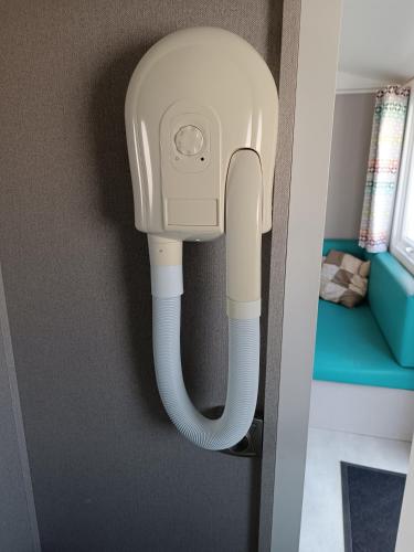 a white phone hanging on a wall at BJ Chalets - Robbengat 85 - Gezellige chalet op vakantiepark Lauwersoog! Vroege incheck! MET AIRCO! in Lauwersoog