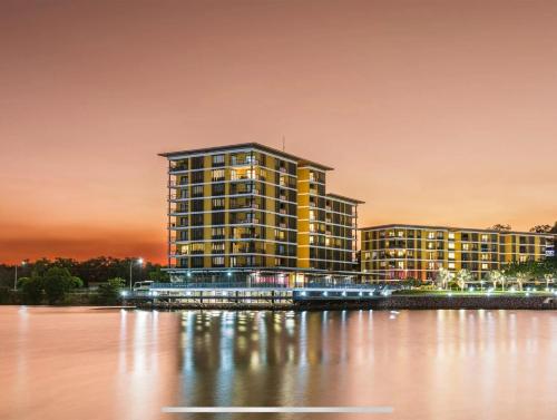a large yellow building next to a body of water at Wharf-view Waterfront Apartment in Darwin