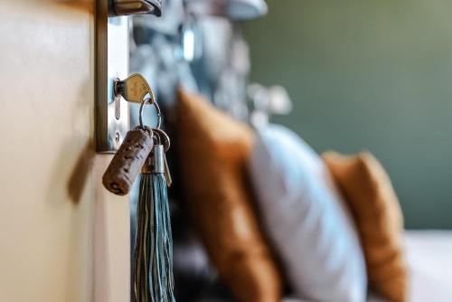 a key is hanging on a door with pillows at Le Sens Six in Montpellier