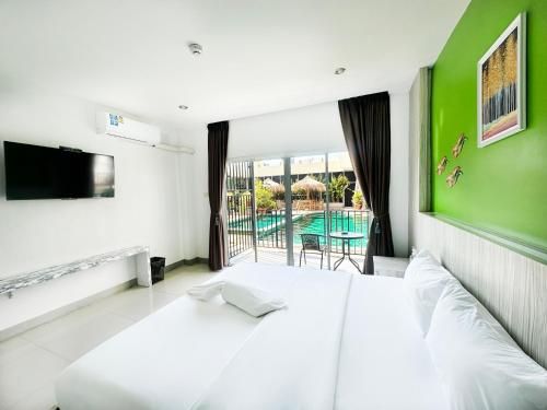 1 dormitorio con cama blanca y pared verde en Anantra Pattaya Resort, en Pattaya central