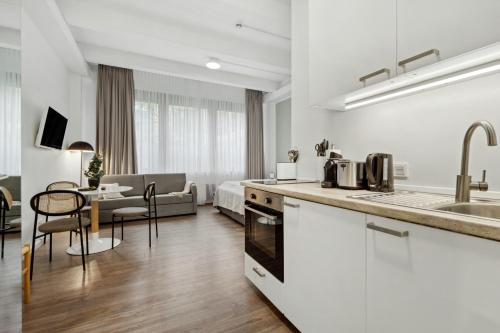 een keuken en een woonkamer met een wastafel en een bank bij limehome Munich Fritz-Erler Str in München