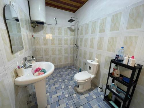 La salle de bains est pourvue d'un lavabo blanc et de toilettes. dans l'établissement Appartement Aachen, à Yaoundé