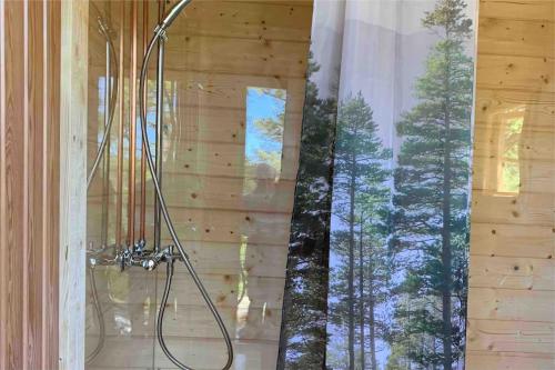 um chuveiro na casa de banho com vista para a floresta em Bastukleven, stuga i Hamnsundets skärgårds idyll em Saltvik