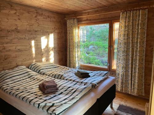 1 dormitorio con 2 camas y ventana en Bastukleven, stuga i Hamnsundets skärgårds idyll, en Saltvik