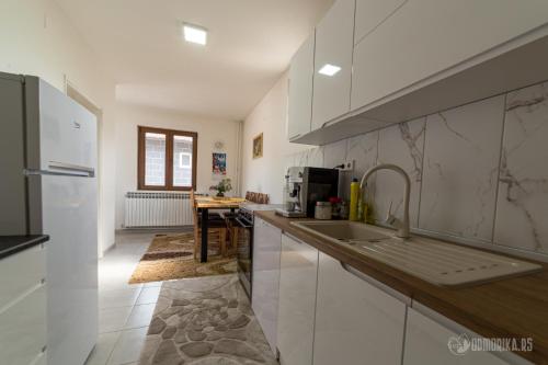 a kitchen with white cabinets and a sink at BB Sima in Bajina Bašta