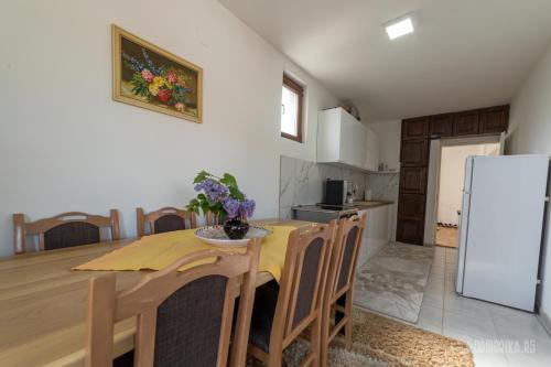 a kitchen with a wooden table and a refrigerator at BB Sima in Bajina Bašta