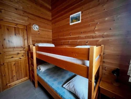 um quarto com um beliche num chalé de madeira em Sfeervolle en ruime chalet Il Mondo em Mauroux