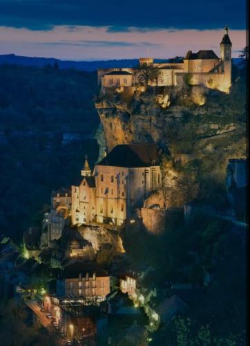 a castle on top of a mountain at night at Maison du Chapitre in Prudhomat