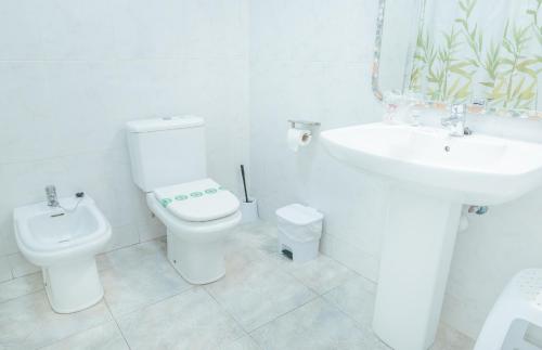 a white bathroom with a toilet and a sink at Hotel Duc de Vendôme in Vinaròs