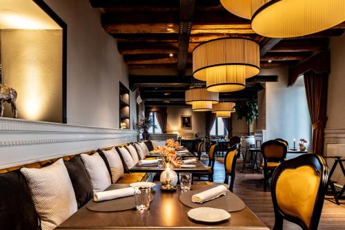 a restaurant with long tables and chairs and lights at Palazzo Boyl 1840 in Cagliari