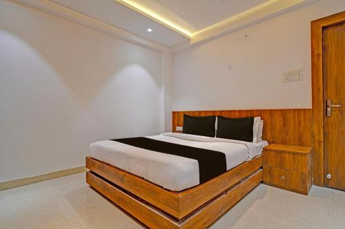 OYO Hotel Delight Stay في إندوري: غرفة نوم بسرير كبير مع اللوح الخشبي