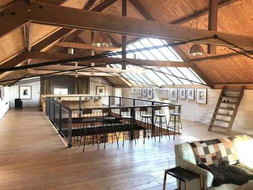 a large loft with wooden floors and a glass ceiling at Gallery at Abbey Hall, Eye in Eye