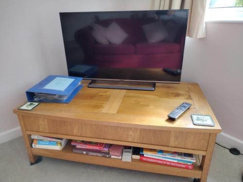 a wooden coffee table with a tv on top of it at Robin Hill Cottage in Amesbury