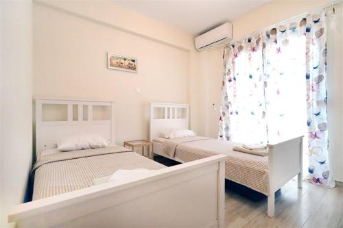Un dormitorio con dos camas y una ventana. en Sirius Villa Nikiti Sithonia Halkidiki 3 bedrooms 8 guests, en Skála Nikíta