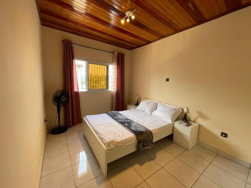 - une chambre avec un lit et un plafond en bois dans l'établissement Appartement Aachen, à Yaoundé