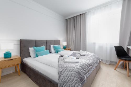 a bedroom with a large bed with blue pillows at Plac Słowiański Apartments with Balcony Świnoujście Center by Renters in Świnoujście