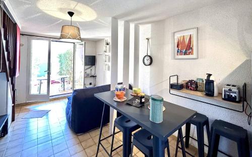 une cuisine et un salon avec une table et des chaises dans l'établissement Maisonnette à 2 min de la plage agréable pour les vacances 4BRI326, au Barcarès