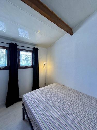 une chambre avec un lit et deux fenêtres dans l'établissement Maisonnette à 2 min de la plage agréable pour les vacances 4BRI326, au Barcarès