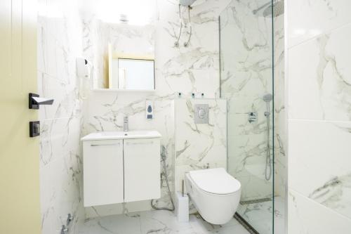 uma casa de banho branca com um WC e um chuveiro em Prego Lux em Ulcinj