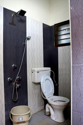a bathroom with a toilet and a shower at Paradise White Villa in Puducherry