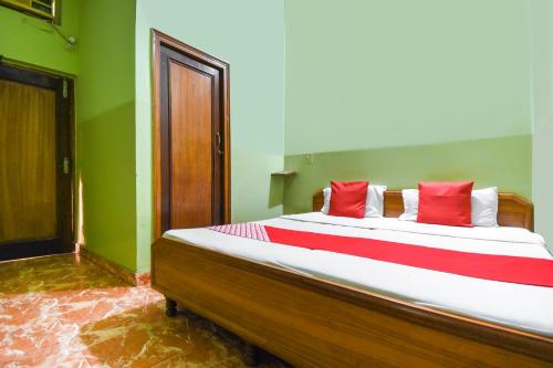 a bedroom with a large bed with red pillows at Hotel Poojan Heritage in Haridwār