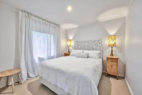 a white bedroom with a white bed and a window at Jamieson Cottages - Cottage Four - Sleeps 4 in Howqua