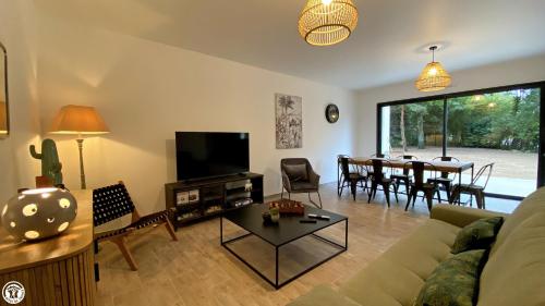 a living room with a couch and a table at Appart 'Hôtel BreakIsleBed Limoges CHU & Fac Médecine Pharma à Pied parking gratuit in Isle