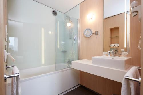 a bathroom with a sink and a shower at Mercure Valenciennes Centre in Valenciennes