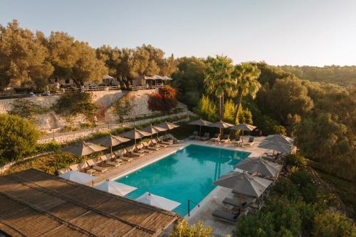 an aerial view of a resort pool with umbrellas at Finca Serena Mallorca, Small Luxury Hotels in Montuiri