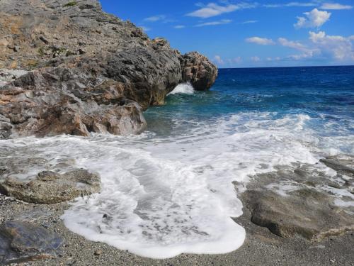 a rocky beach with water crashing on the rocks at La vita è bella - Noli in Noli