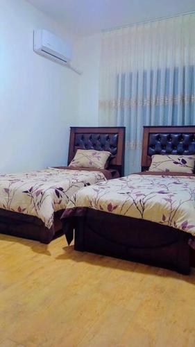 two beds sitting next to each other in a room at شقة فاخرة واسعة في شارع المدينة المنورة in Umm Uthainah