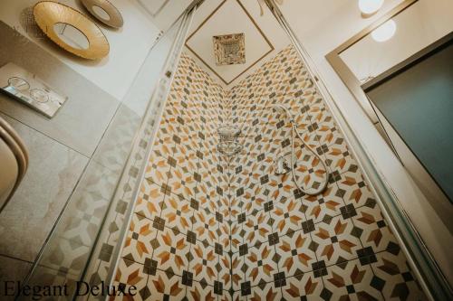 a bathroom with a tiled floor with a wall at Vili Apartments in Oradea