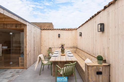 an outdoor patio with a wooden table and chairs at Casa Diva – renovated house for 12 in Blankenberge in Blankenberge