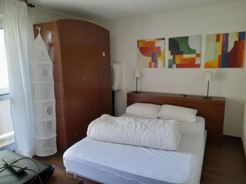 - une chambre avec un lit blanc et une étagère dans l'établissement appart 6 personnes La Mongie, à Bagnères-de-Bigorre