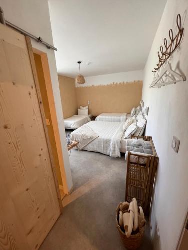 a bedroom with two beds and a hallway at Demeure du Mas de Bessac in Brengues