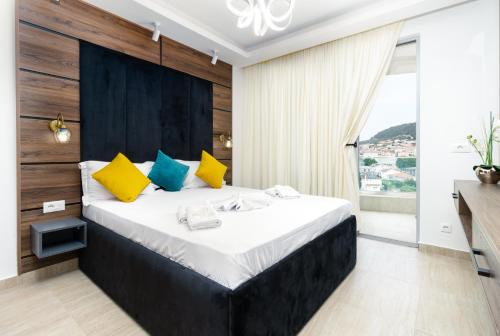 1 dormitorio con 1 cama grande con almohadas amarillas y azules en Prego Lux en Ulcinj