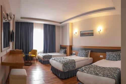 een hotelkamer met 2 bedden en een bureau bij AĞAOĞLU MY TERMAL in Sadıkbey