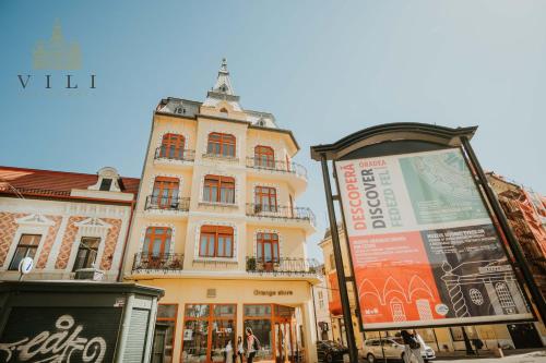a tall building with a sign in front of it at Vili Apartments in Oradea