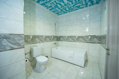 a bathroom with a toilet and a bath tub at AĞAOĞLU MY TERMAL in Sadıkbey