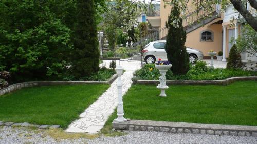 a garden with white statues in the grass at AUTOMOTODROM GROBNIK - Apartments and Rooms Skejić in Čavle