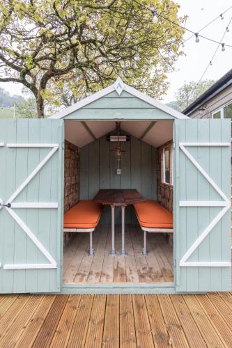 a shed with two chairs and a table in it at Dartmoor Halfway Inn in Newton Abbot
