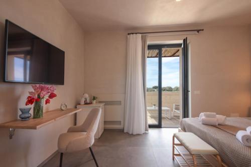 sypialnia z łóżkiem, biurkiem i telewizorem w obiekcie Casale degli Ulivi by Apulia Hospitality w mieście Fasano