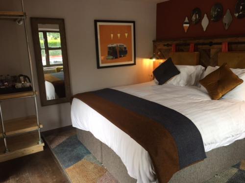 a bedroom with a large bed and a mirror at Dartmoor Halfway Inn in Newton Abbot